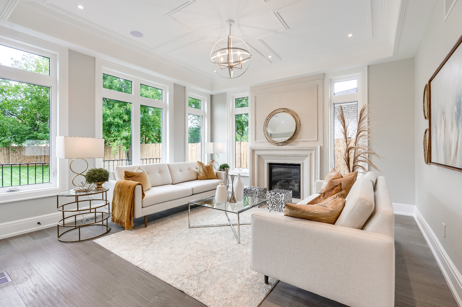 Open-concept living room with coffered ceiling, panelled walls and a stone fireplace